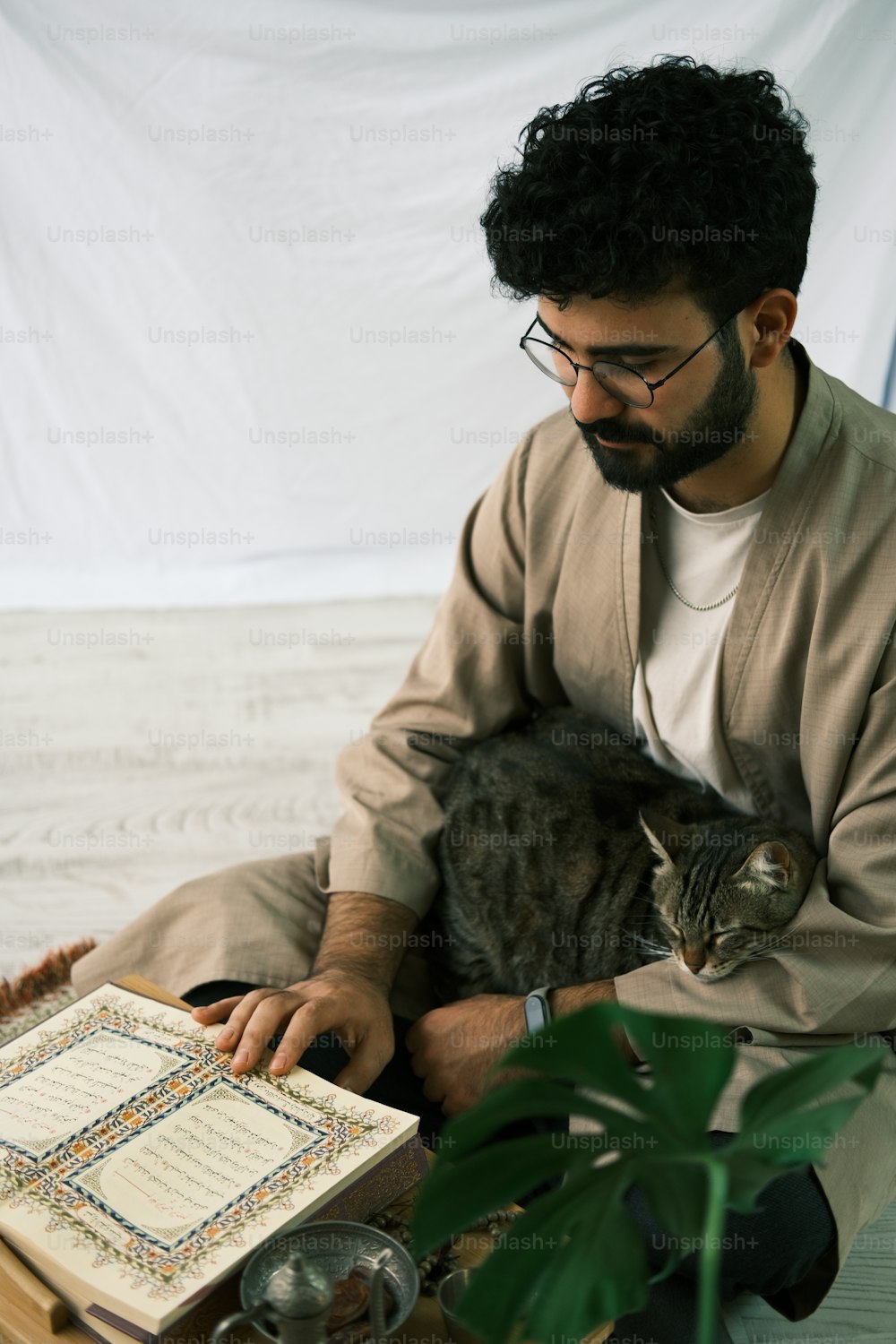 a man sitting down with a cat on his lap
