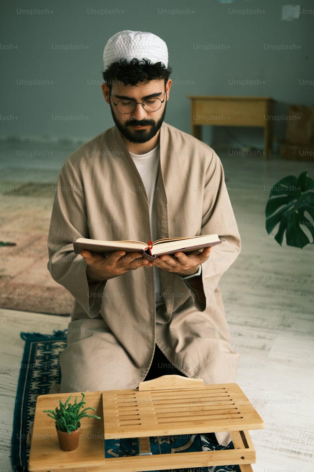 a man sitting on a rug reading a book