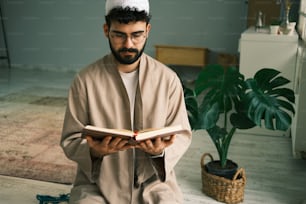 a man sitting on the floor reading a book