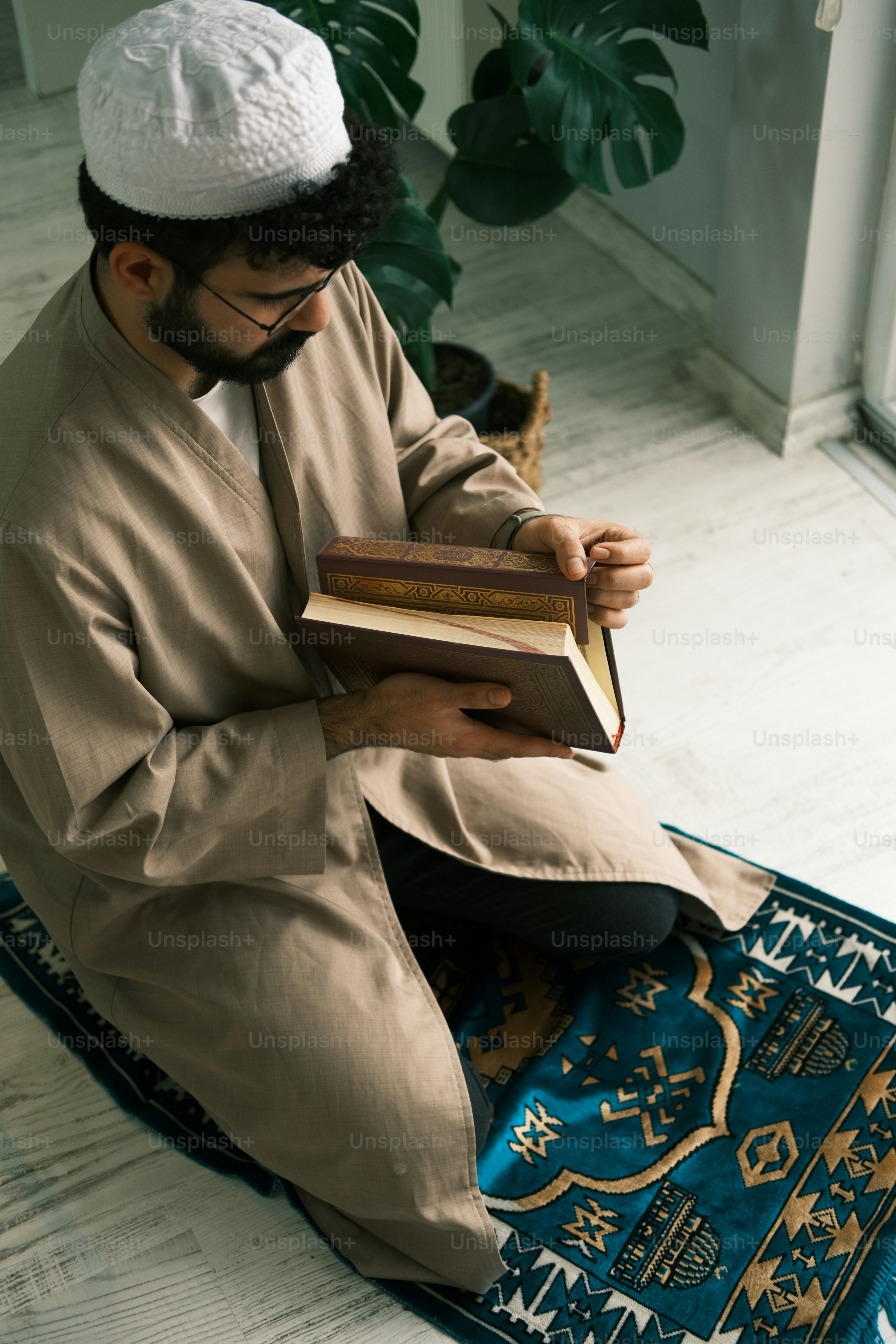 a man sitting on a rug reading a book