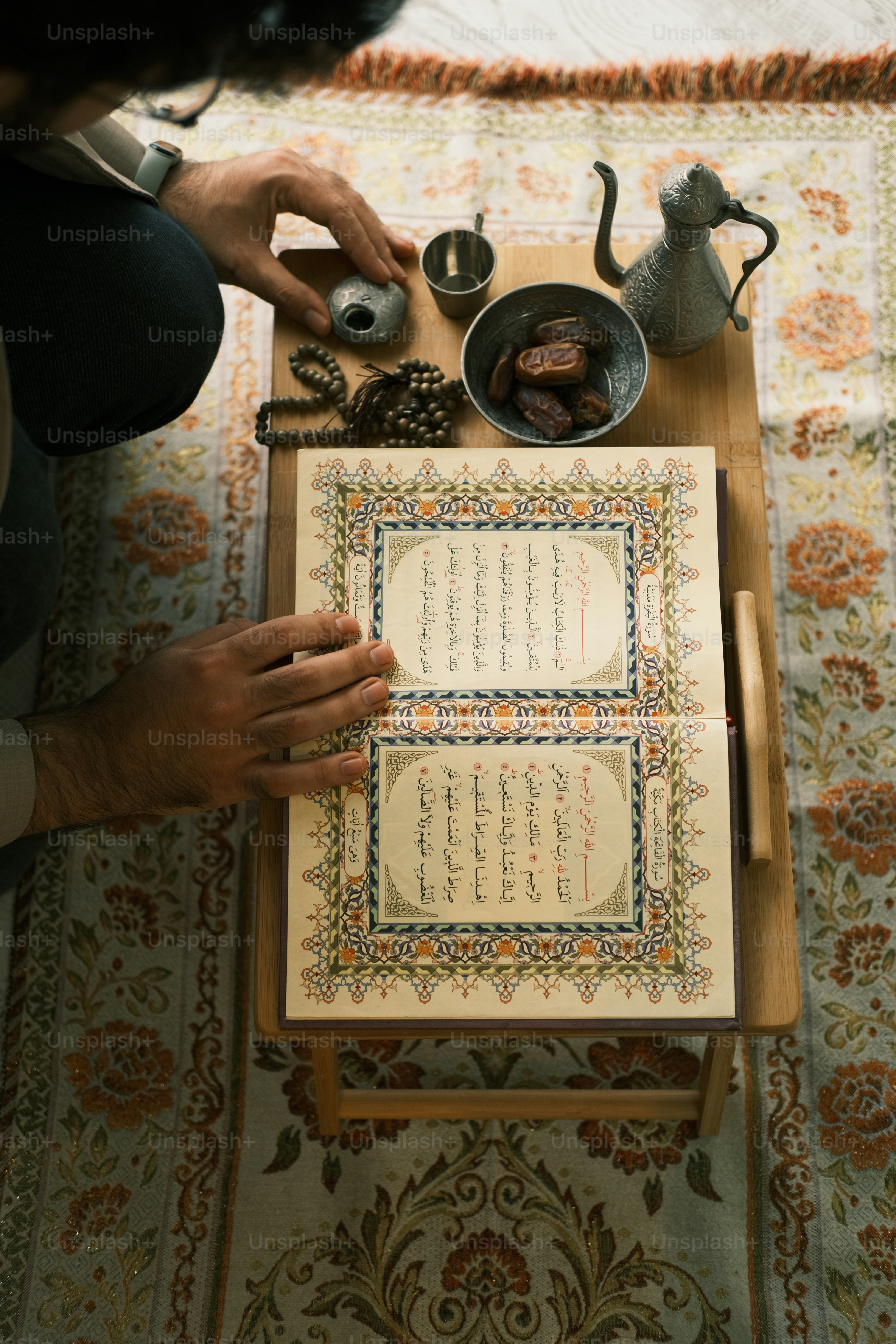 a person sitting at a table with a book and teapot