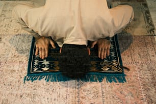 a man in a white shirt is sitting on a rug