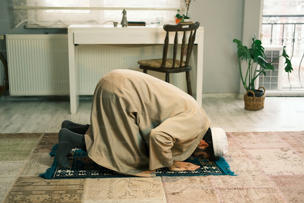 a man kneeling down on a rug in a room