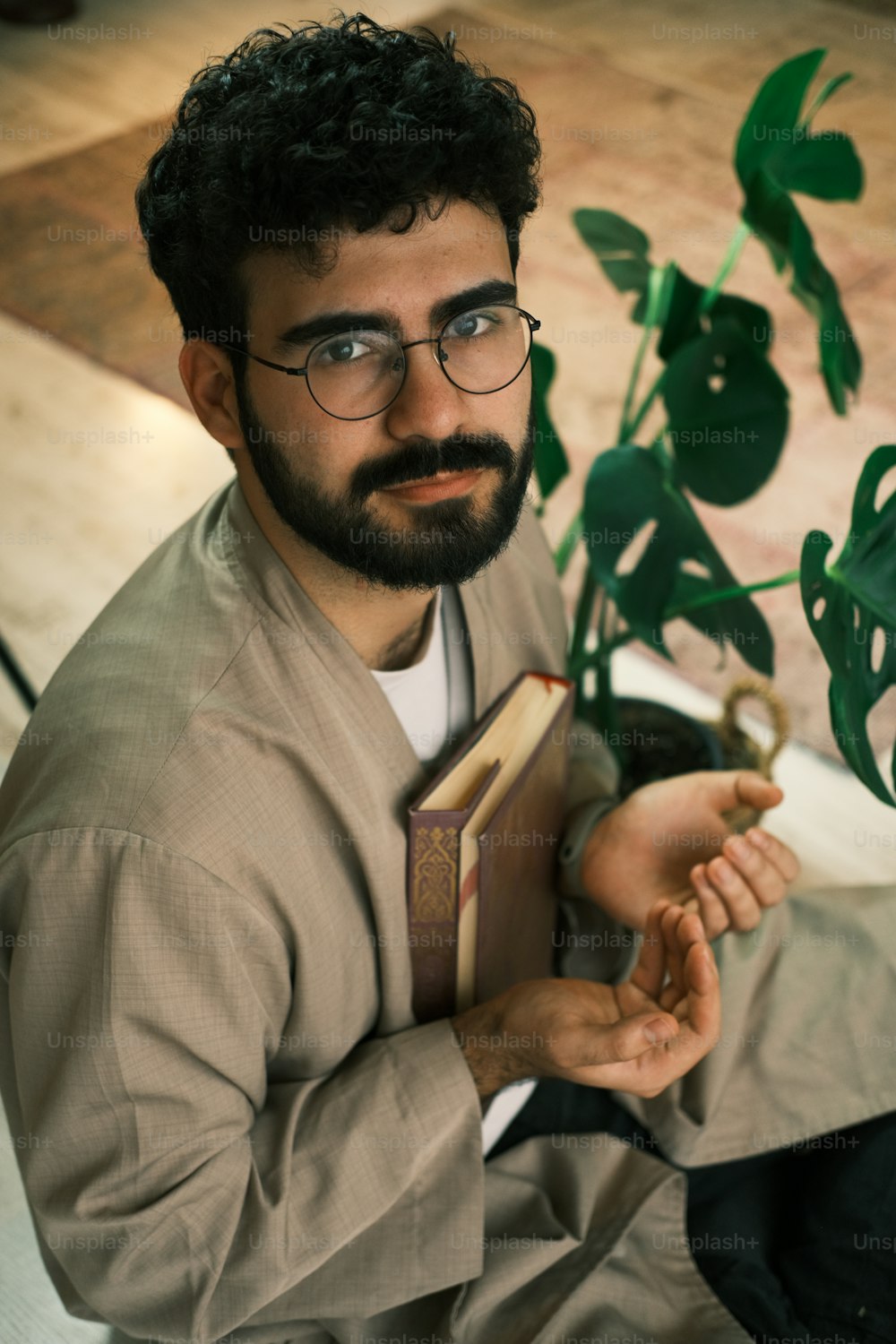 a man with a beard and glasses holding a book