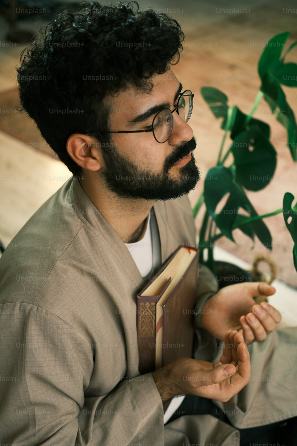 a man with a beard and glasses holding a book