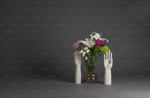 꽃과 두 개의 하얀 손으로 가득 찬 꽃병