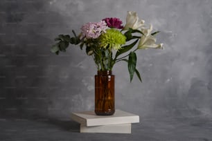 a vase of flowers sitting on top of a book