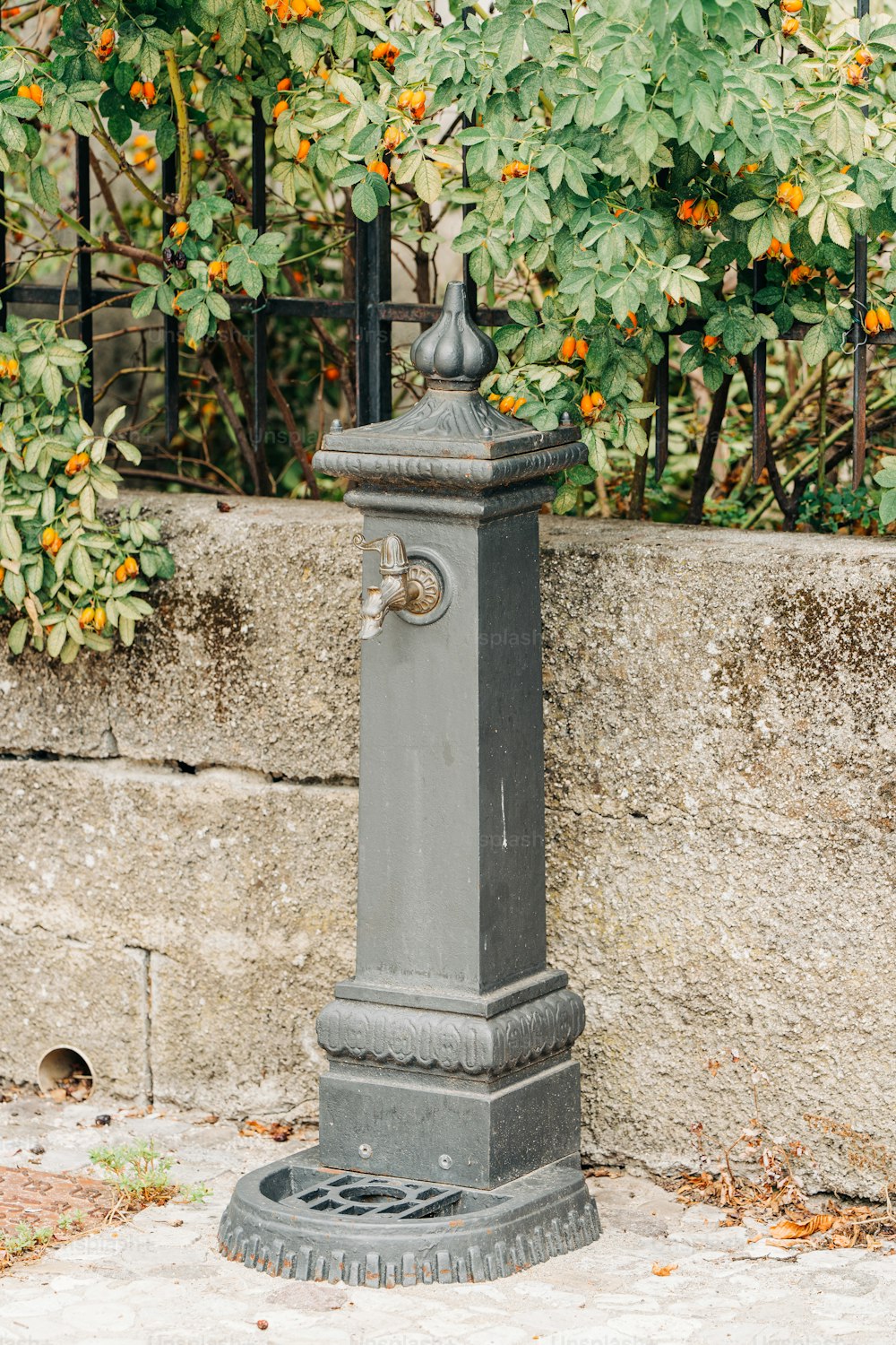 a gray fire hydrant sitting on the side of a road