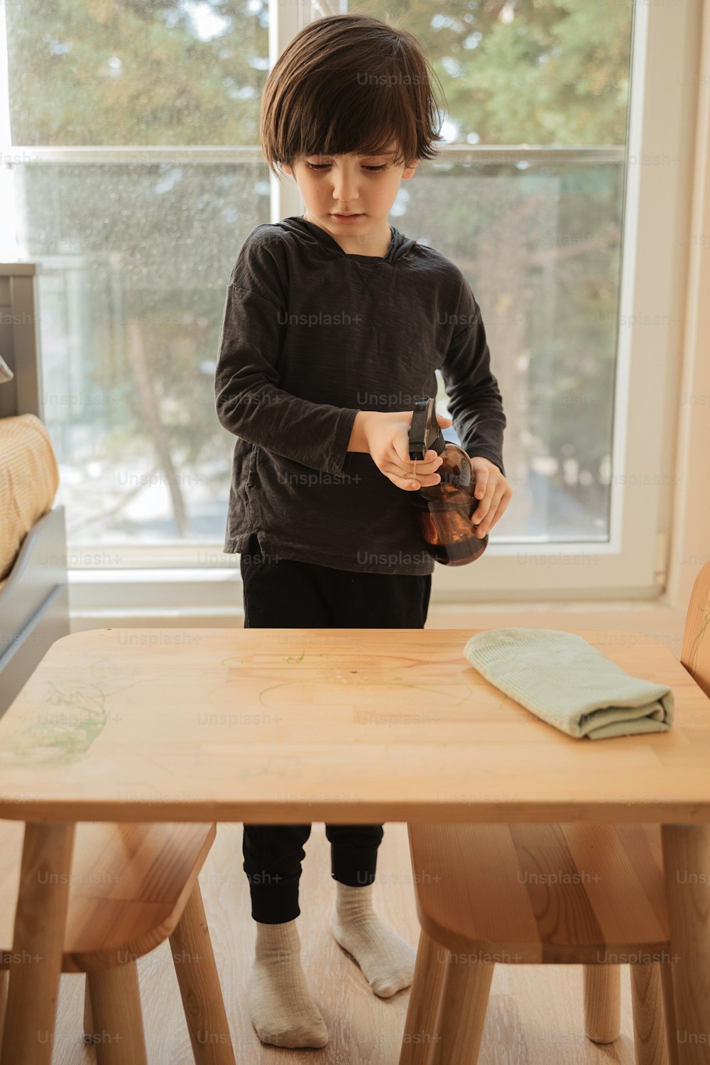 木製のテーブルに立つ少年