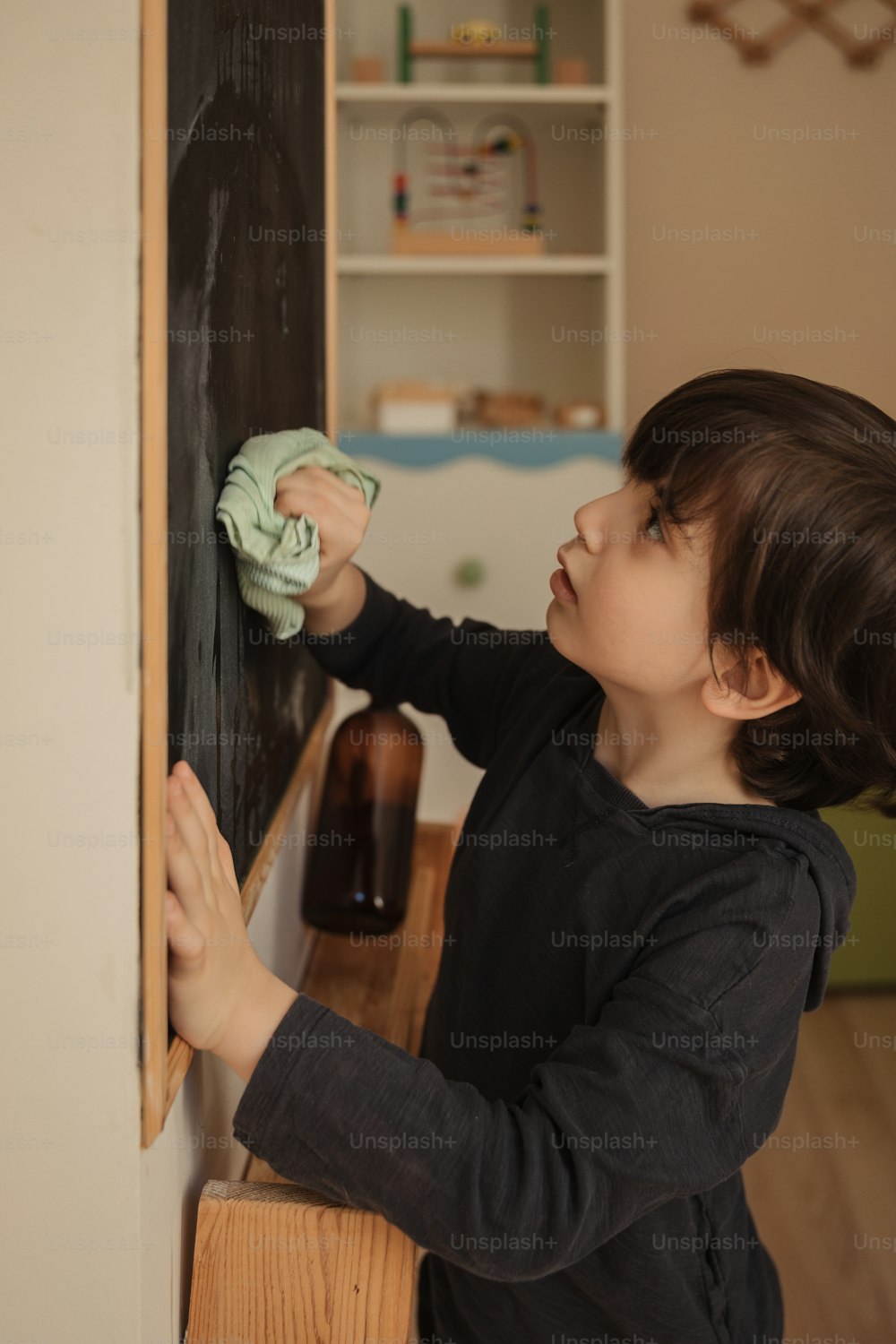 a young child is playing with a blackboard