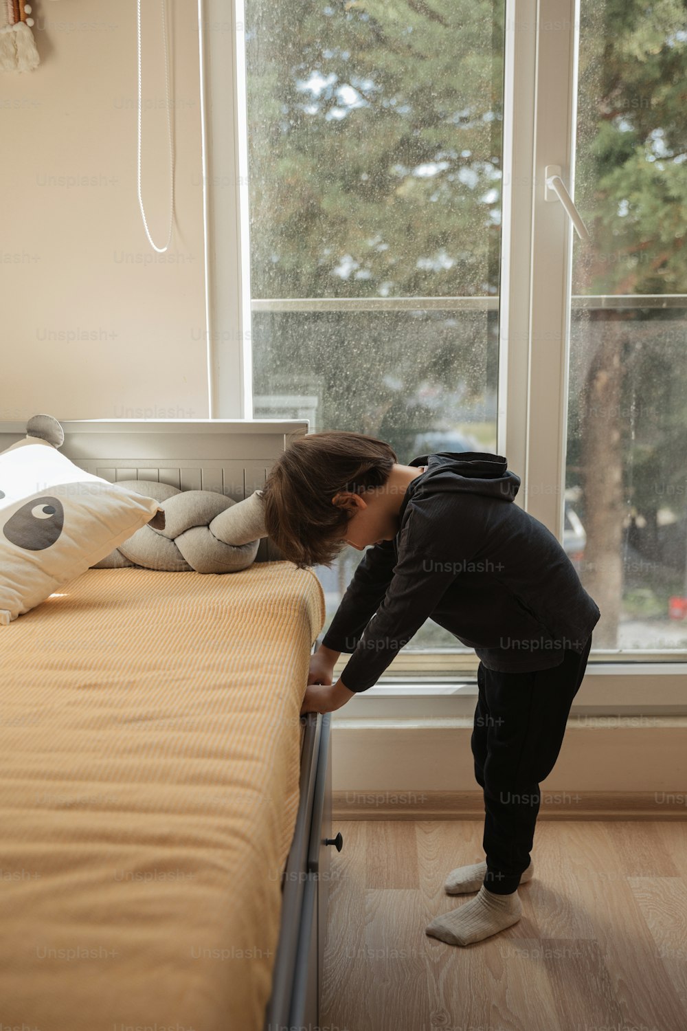 a young girl is bending over to pick up a pillow