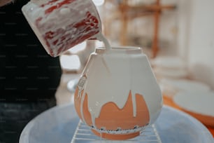 a person pours liquid into a vase on a rack