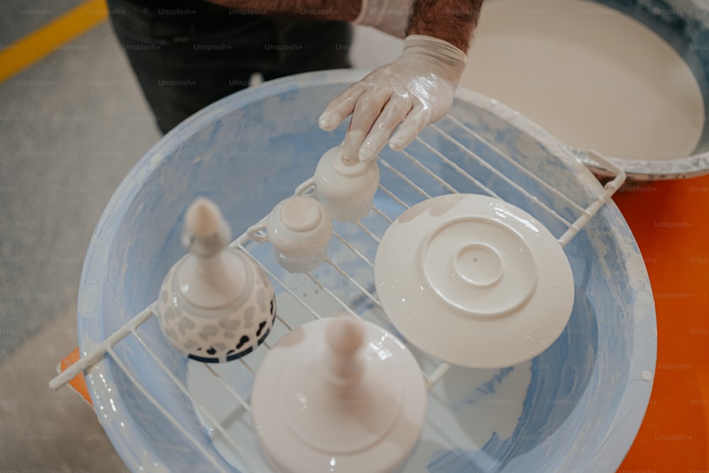 a person in a white glove is mixing something in a blue bowl