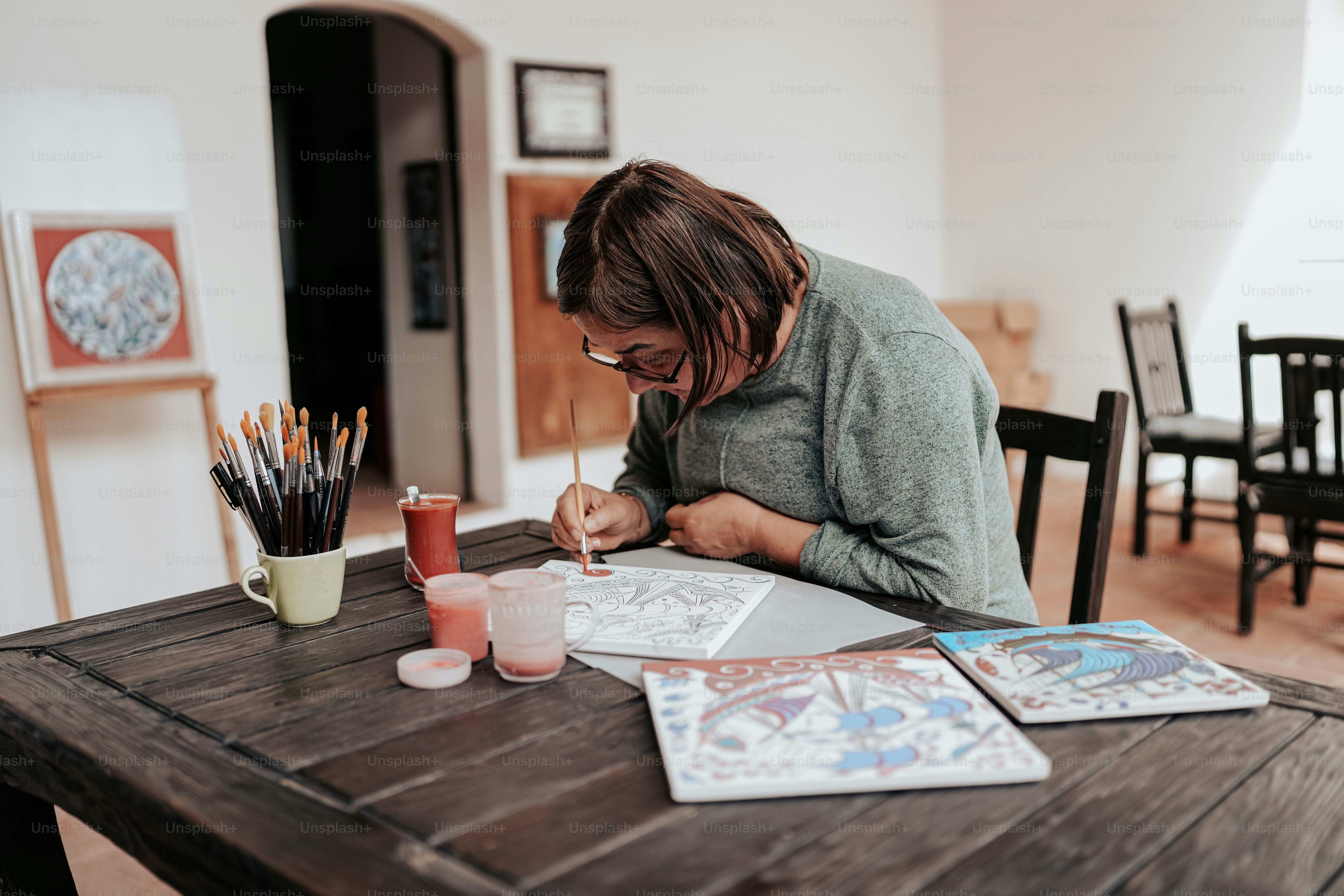 a woman sitting at a table with a notebook and pen