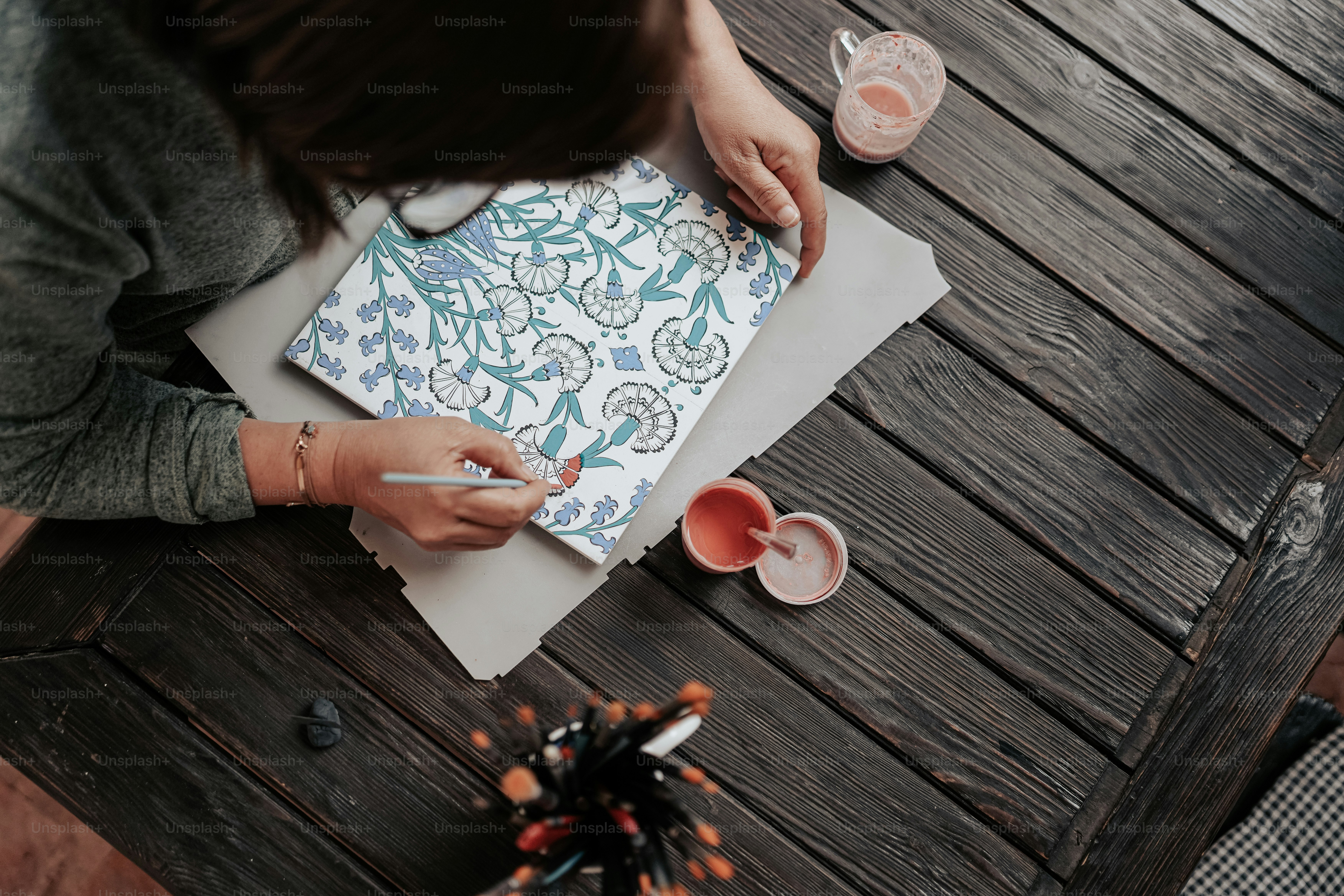 a woman sitting at a table writing on a piece of paper