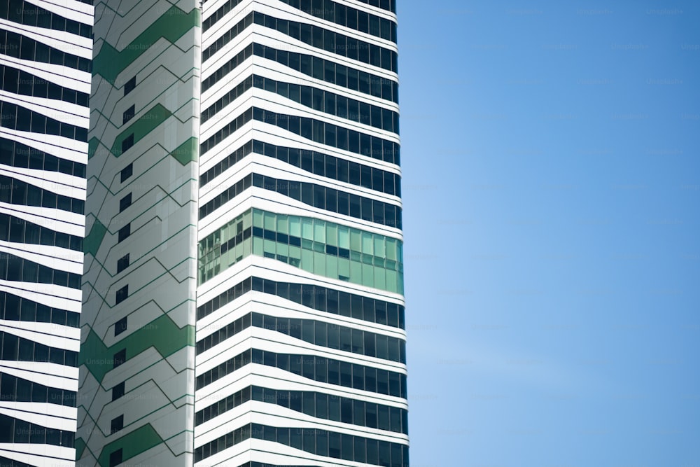 Un alto edificio blanco y verde junto a un cielo azul