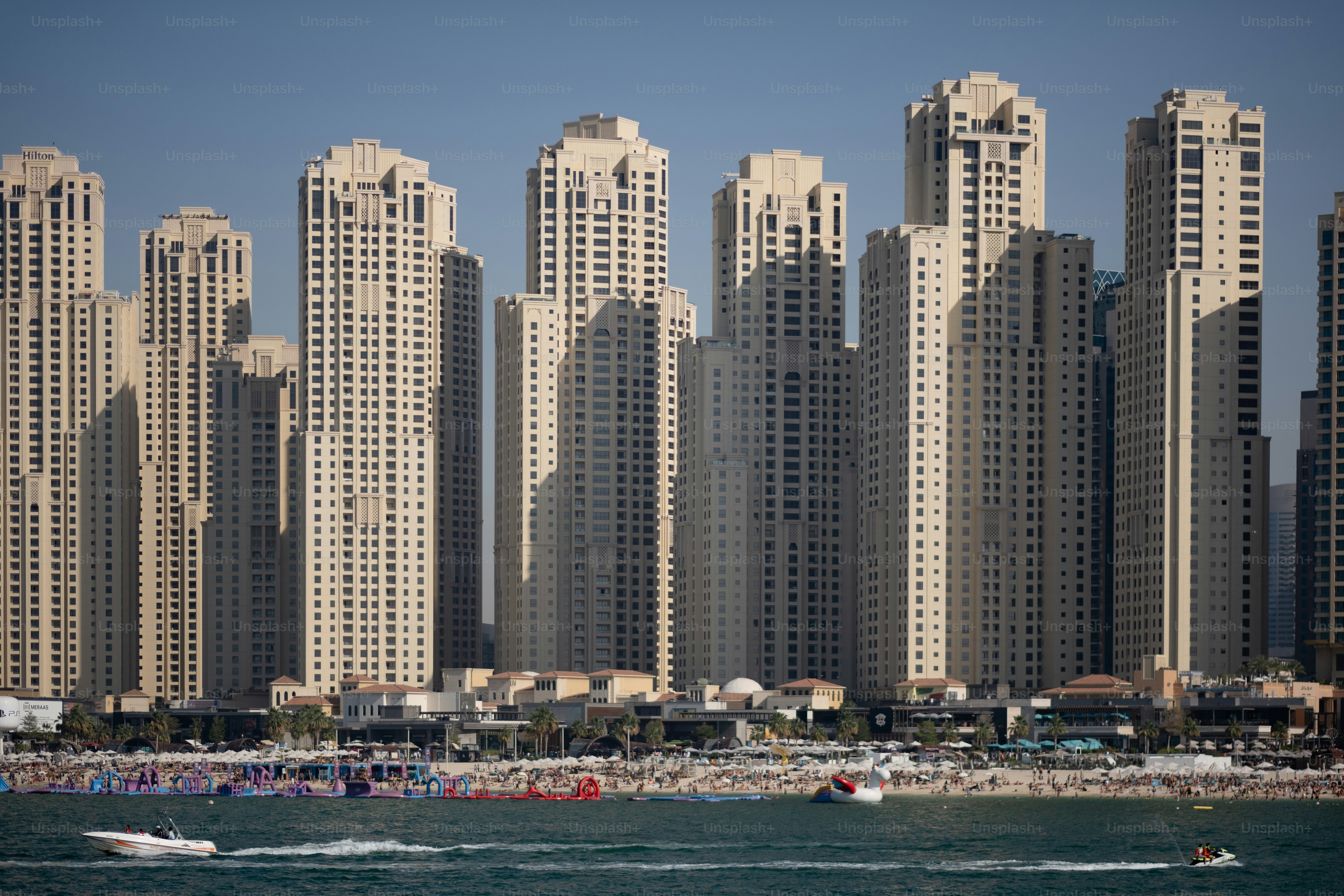 A cluster of high-rise apartment buildings along a crowded beach.