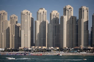 a large group of tall buildings next to a beach