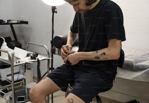 un homme tatoué assis sur une chaise