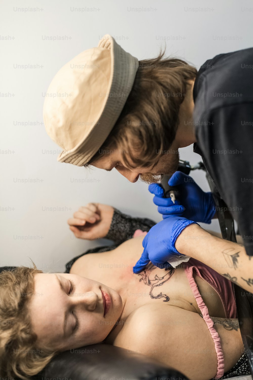 a woman getting a tattoo done by a tattooist