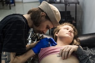 a woman getting her tattoo done by a tattooist