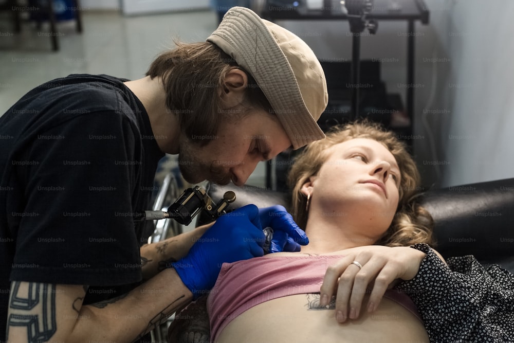 a woman getting her tattoo done by a tattooist