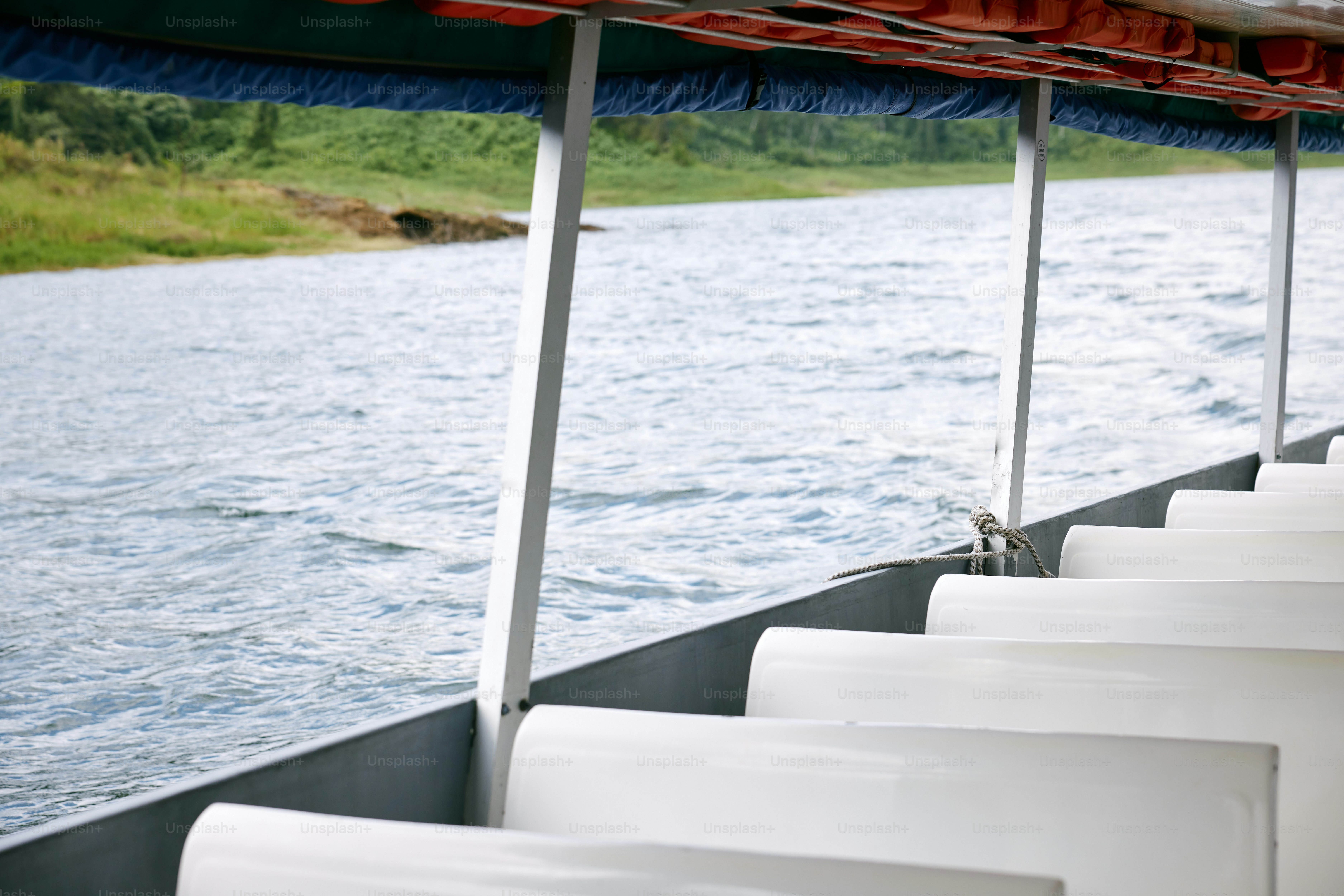 a row of white chairs sitting next to a body of water