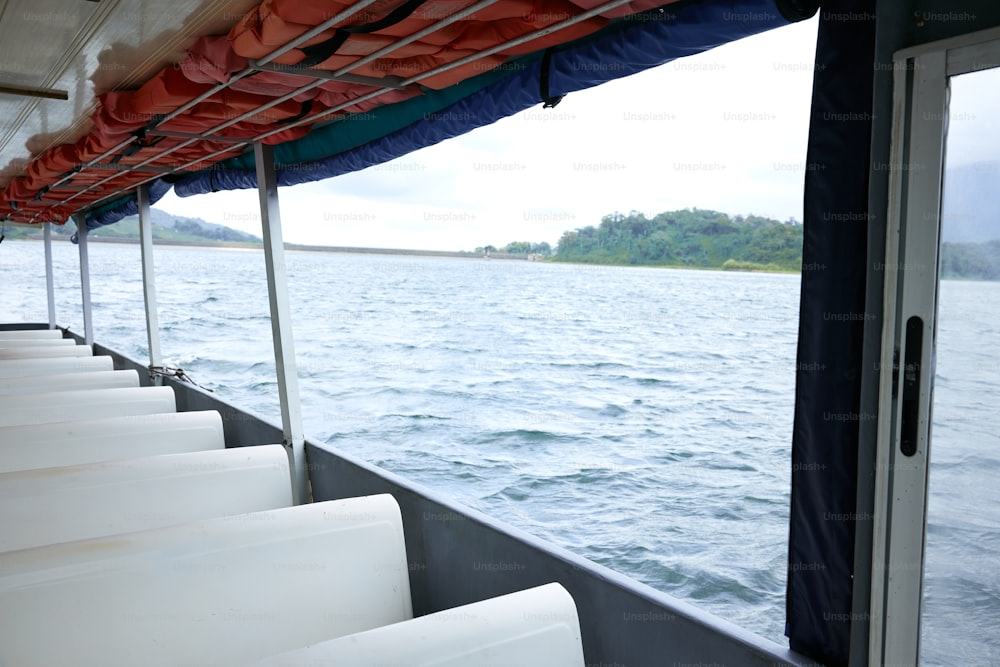 a row of white chairs sitting on top of a boat