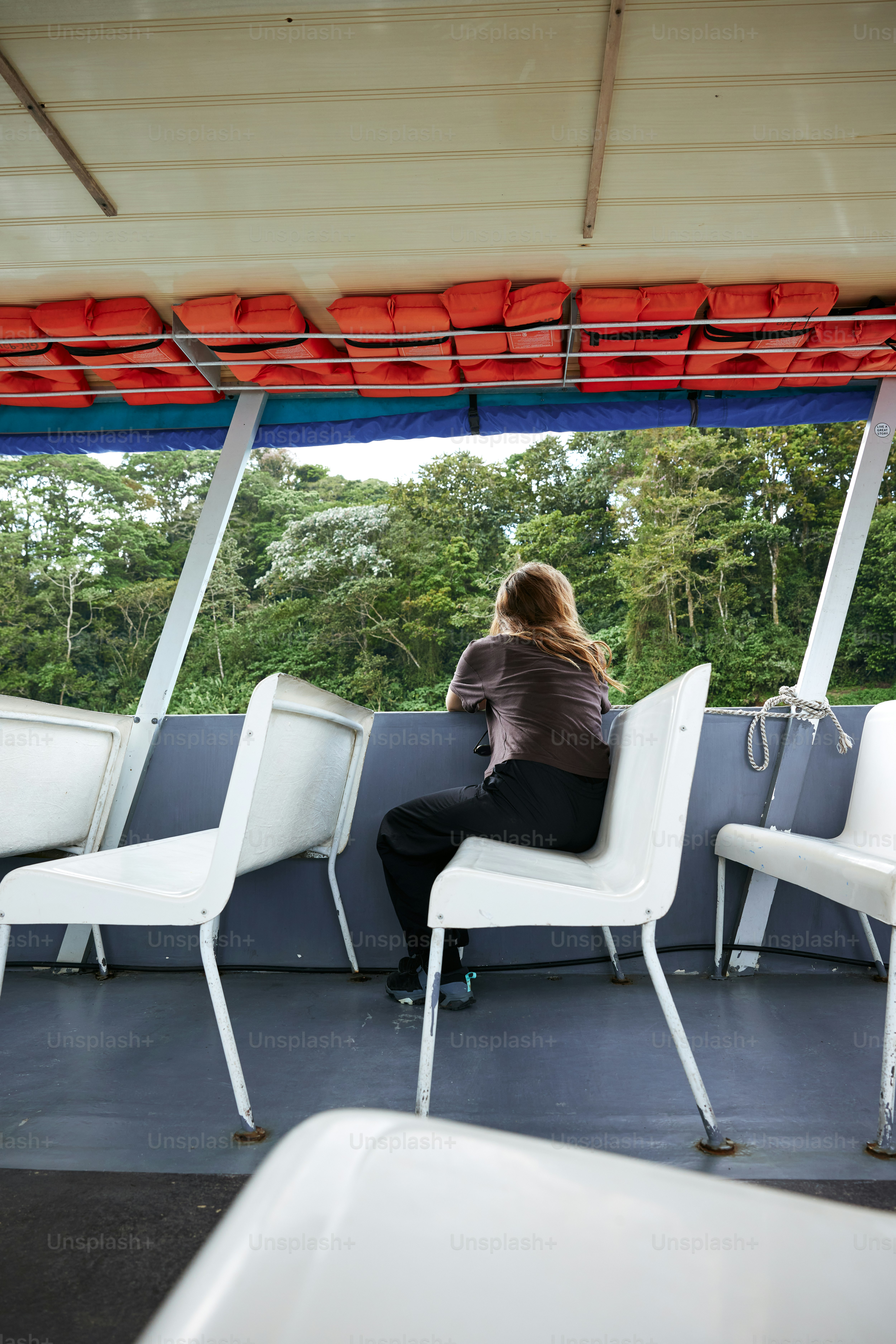 a woman sitting on a white chair looking out a window