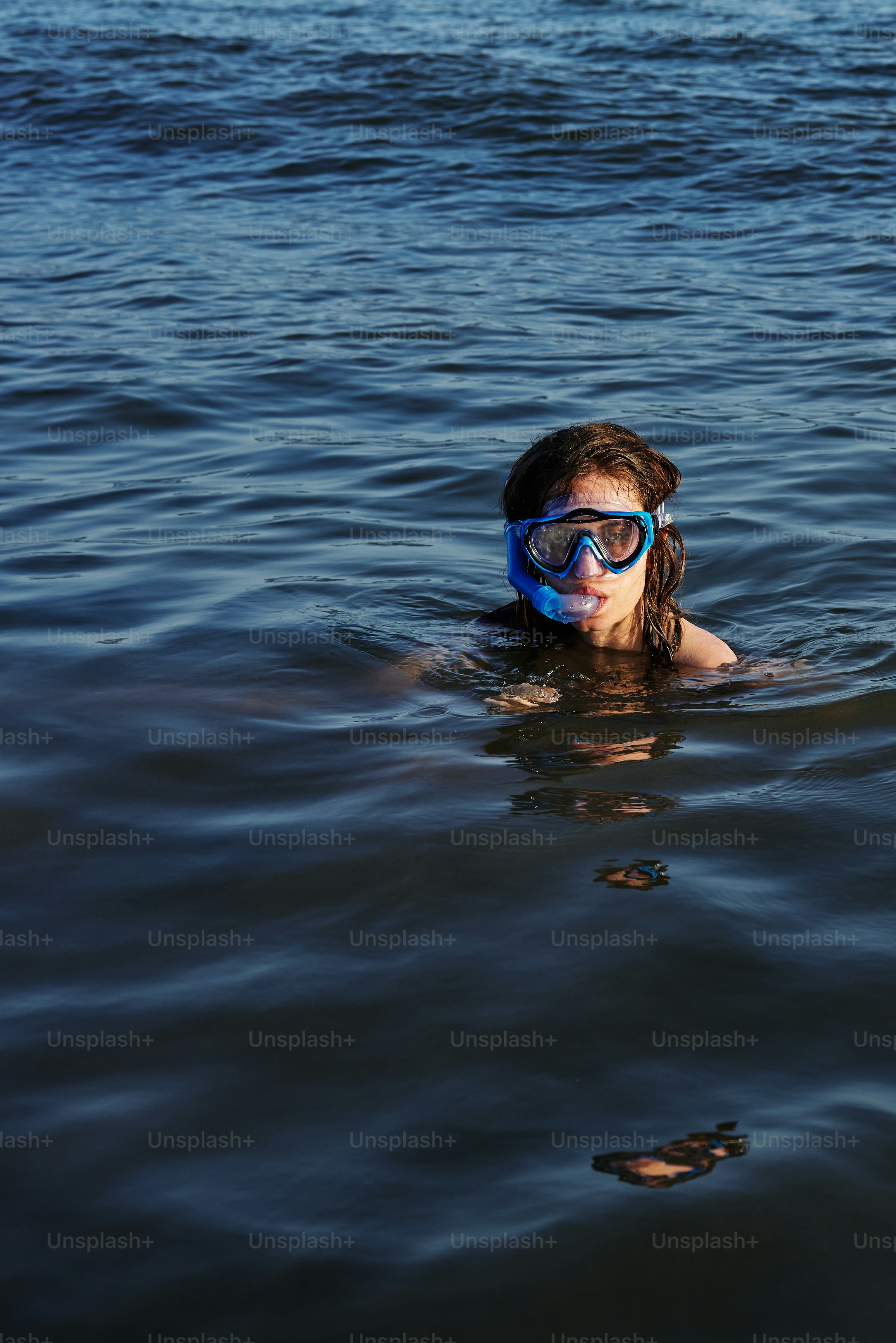 a person swimming in the water with a mask on
