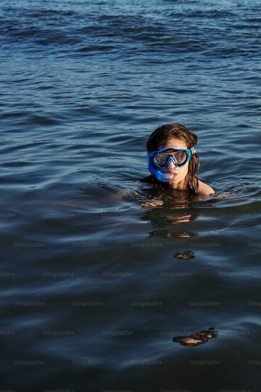eine Person, die mit einer Maske im Wasser schwimmt