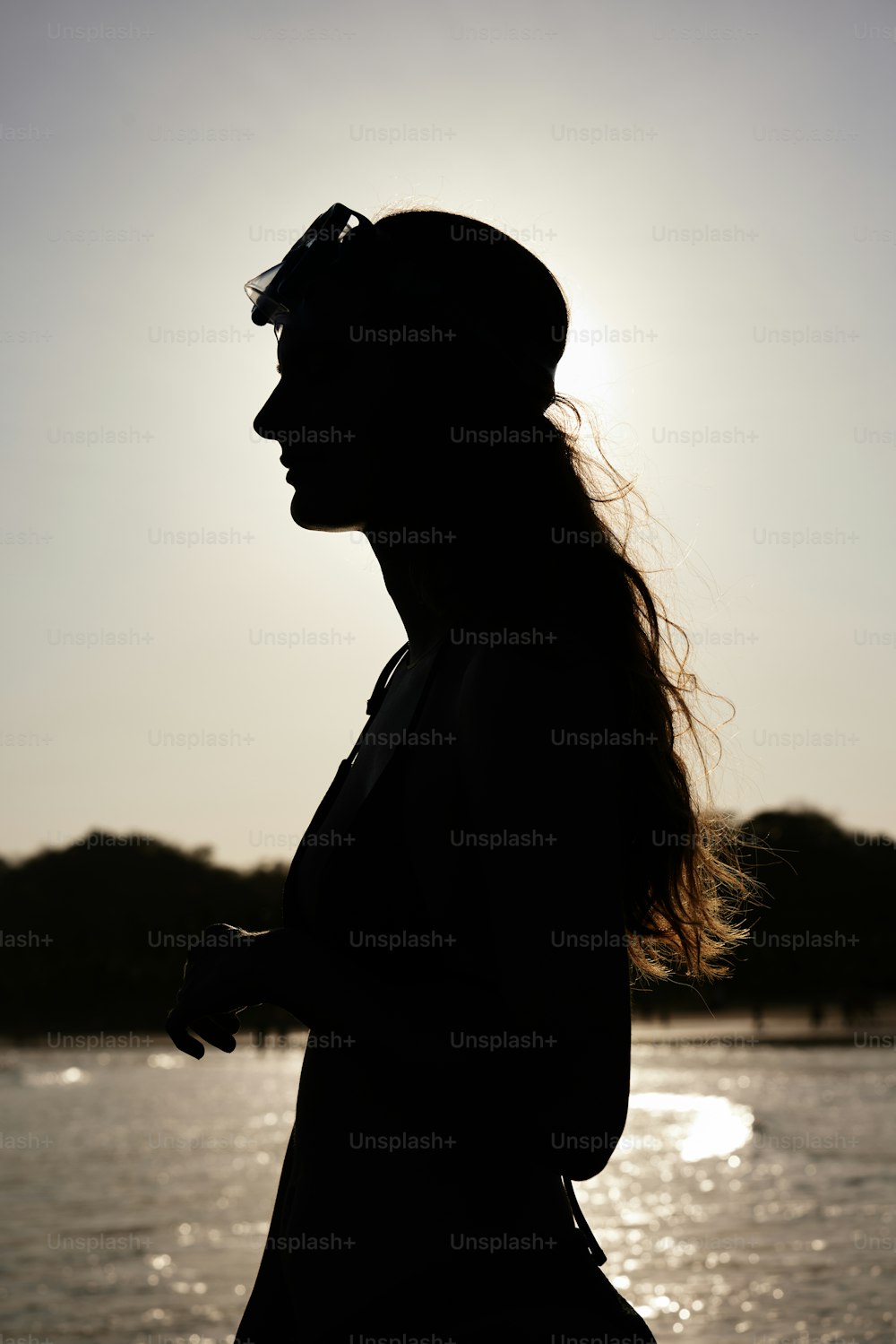 a woman standing in front of a body of water