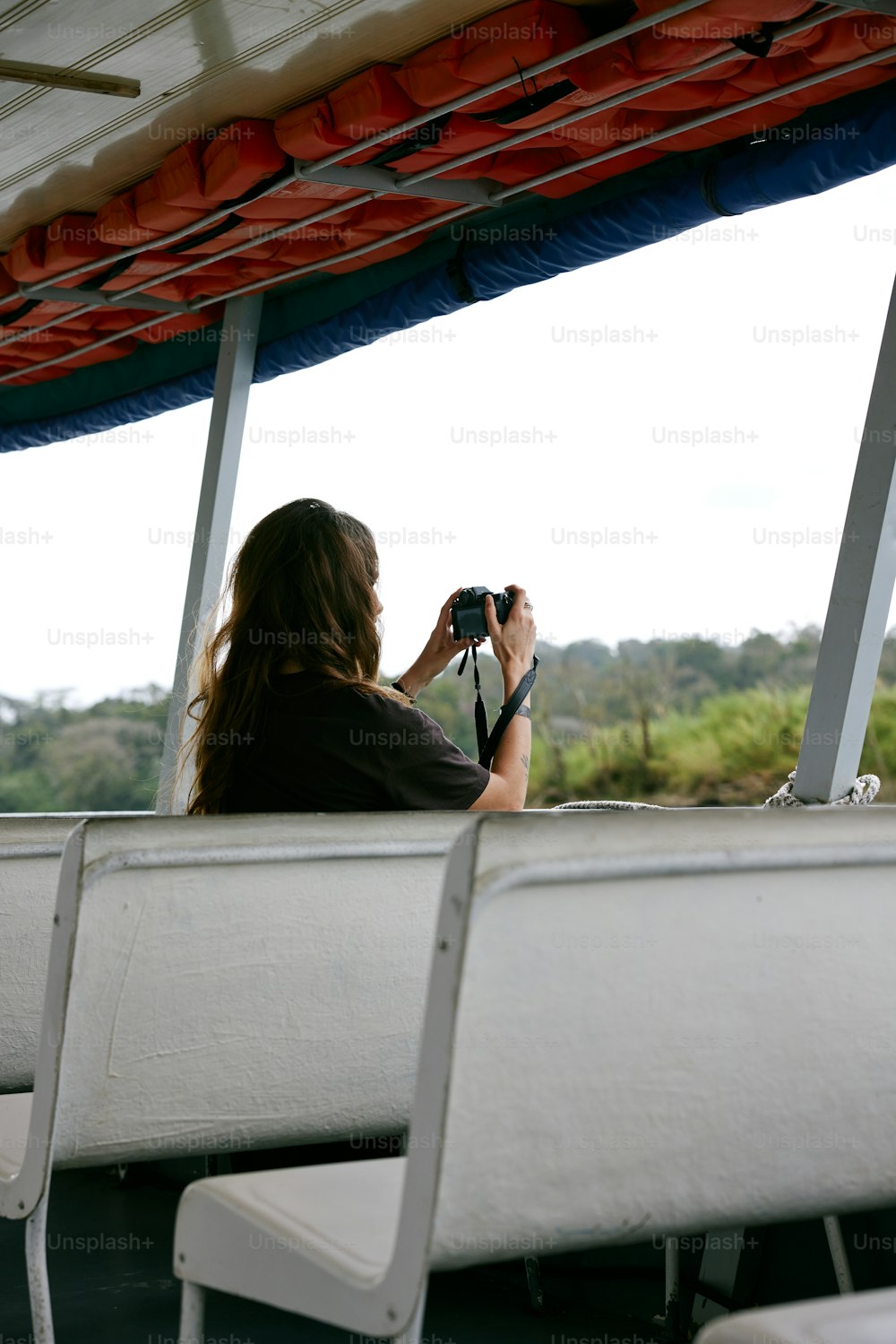 a woman sitting on a bench taking a picture