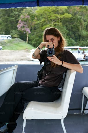 una donna seduta su una sedia che tiene una macchina fotografica