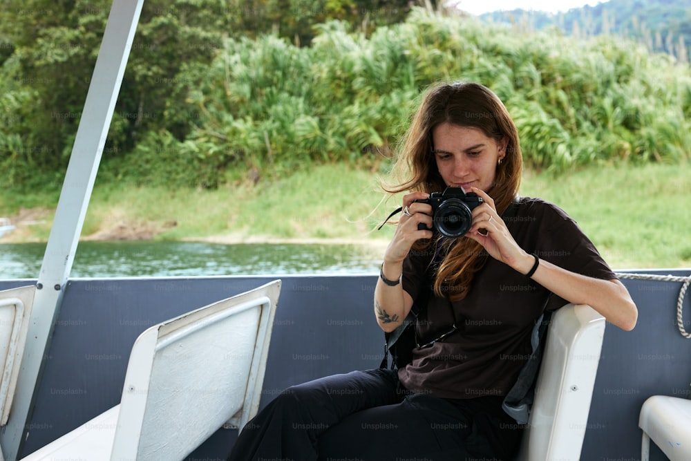 a woman sitting on a boat holding a camera