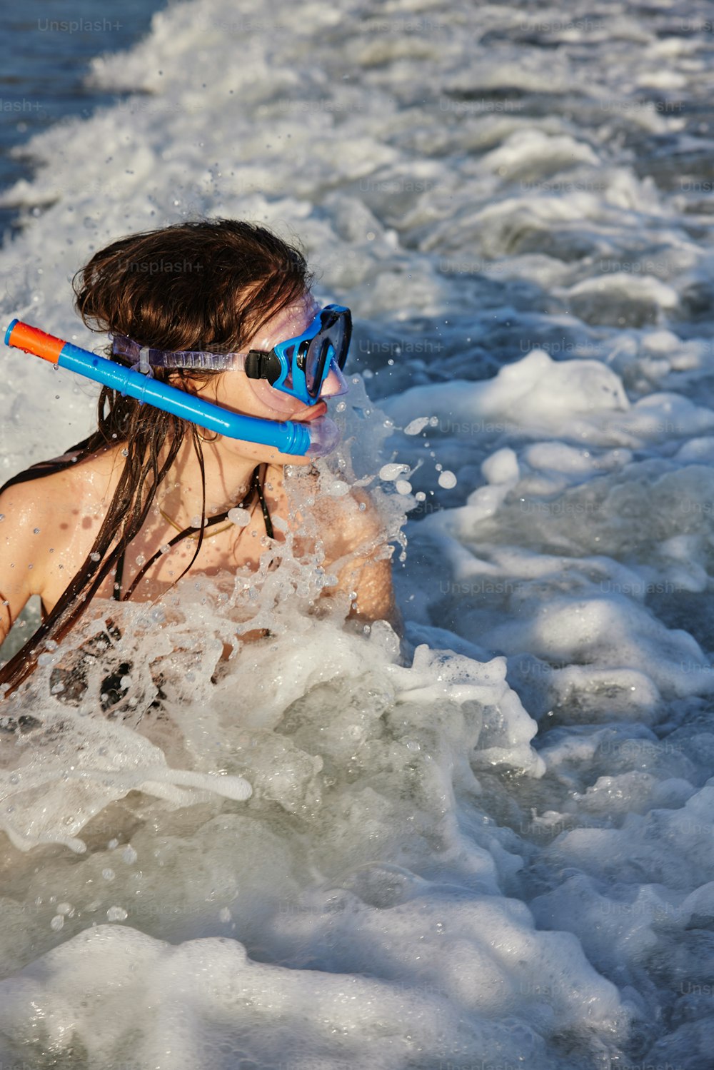 a young girl is swimming in the ocean