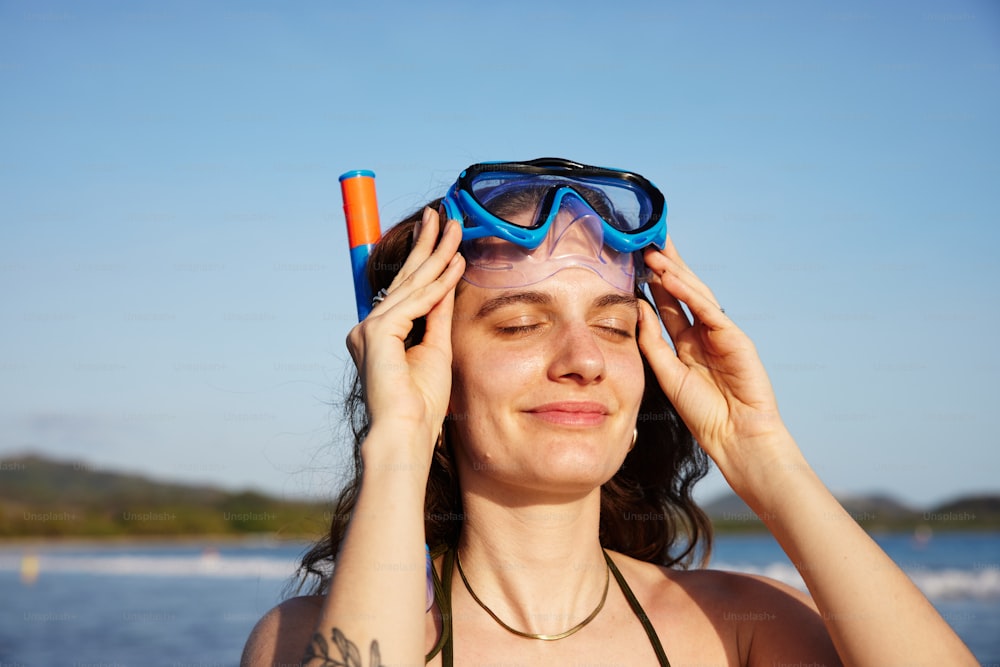 a woman wearing a mask and goggles on her head