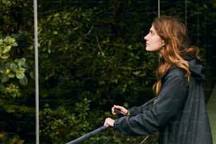 a woman standing on a bridge with trees in the background