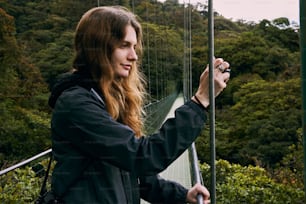 a woman taking a picture of herself on a bridge