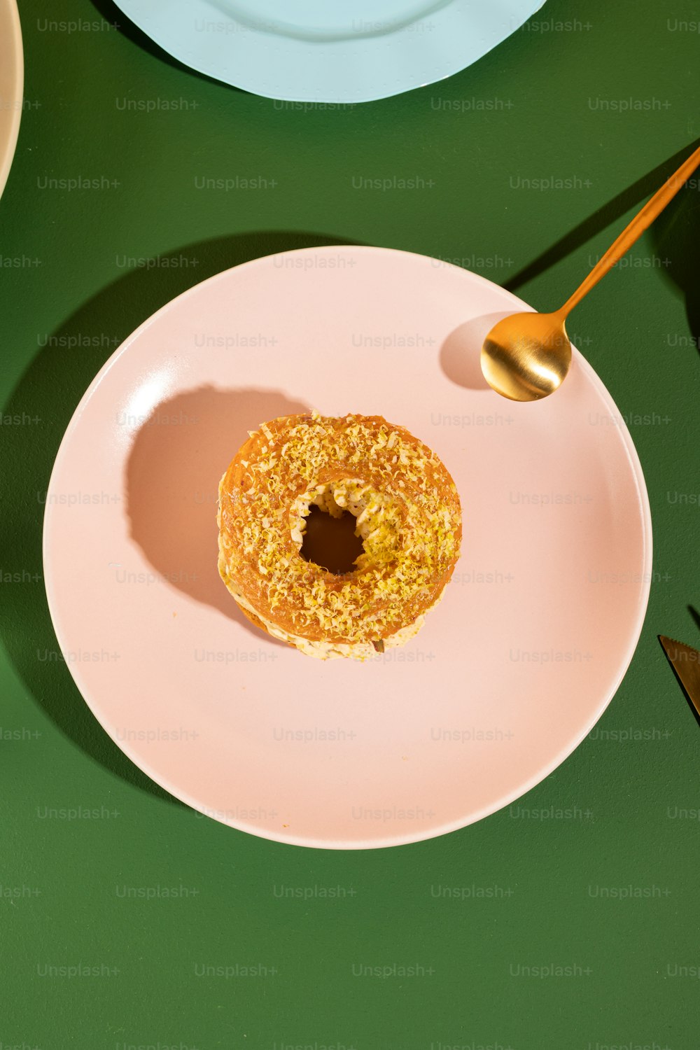 um donut em um prato com uma colher em uma mesa