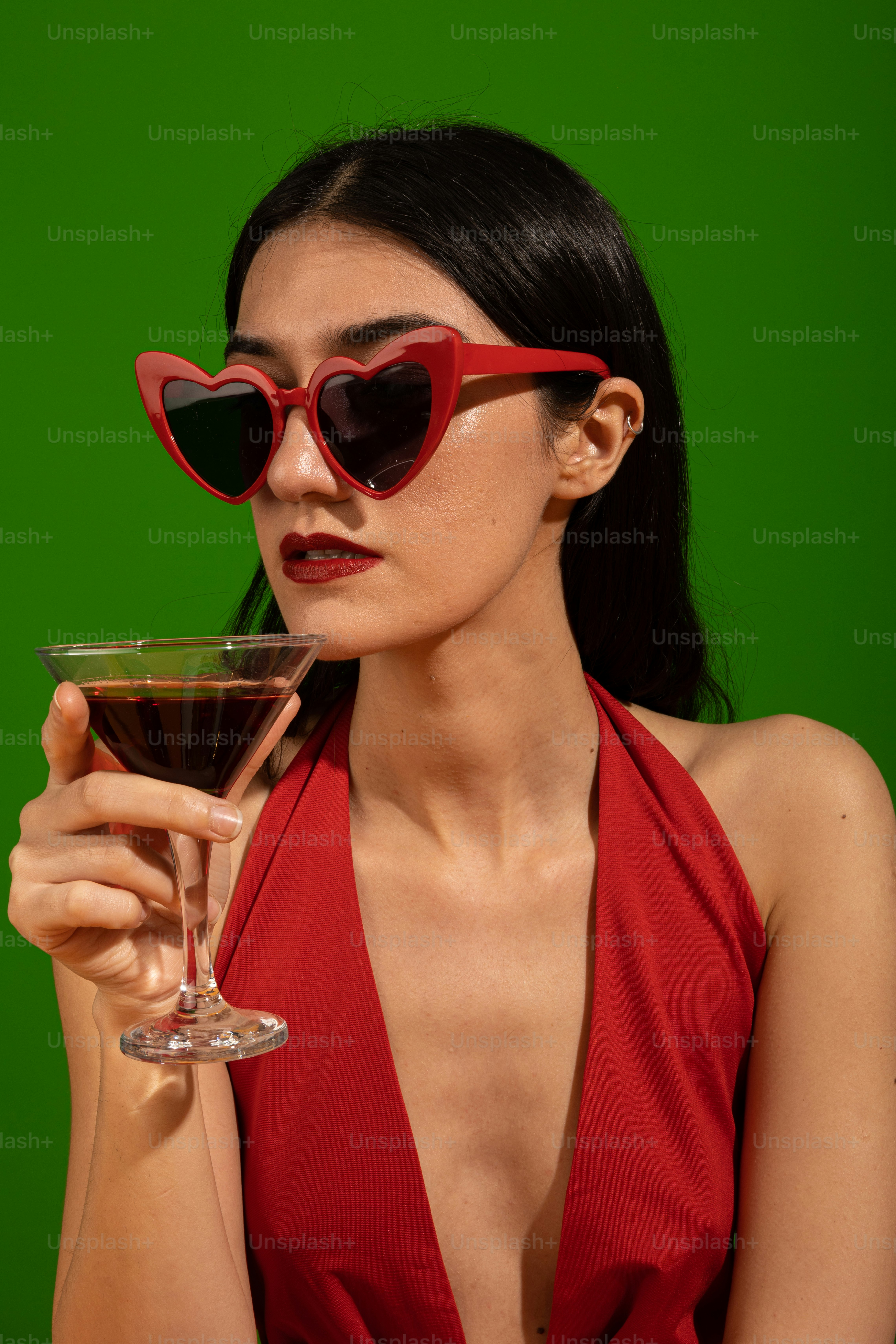 uma mulher em um vestido vermelho segurando um copo de vinho