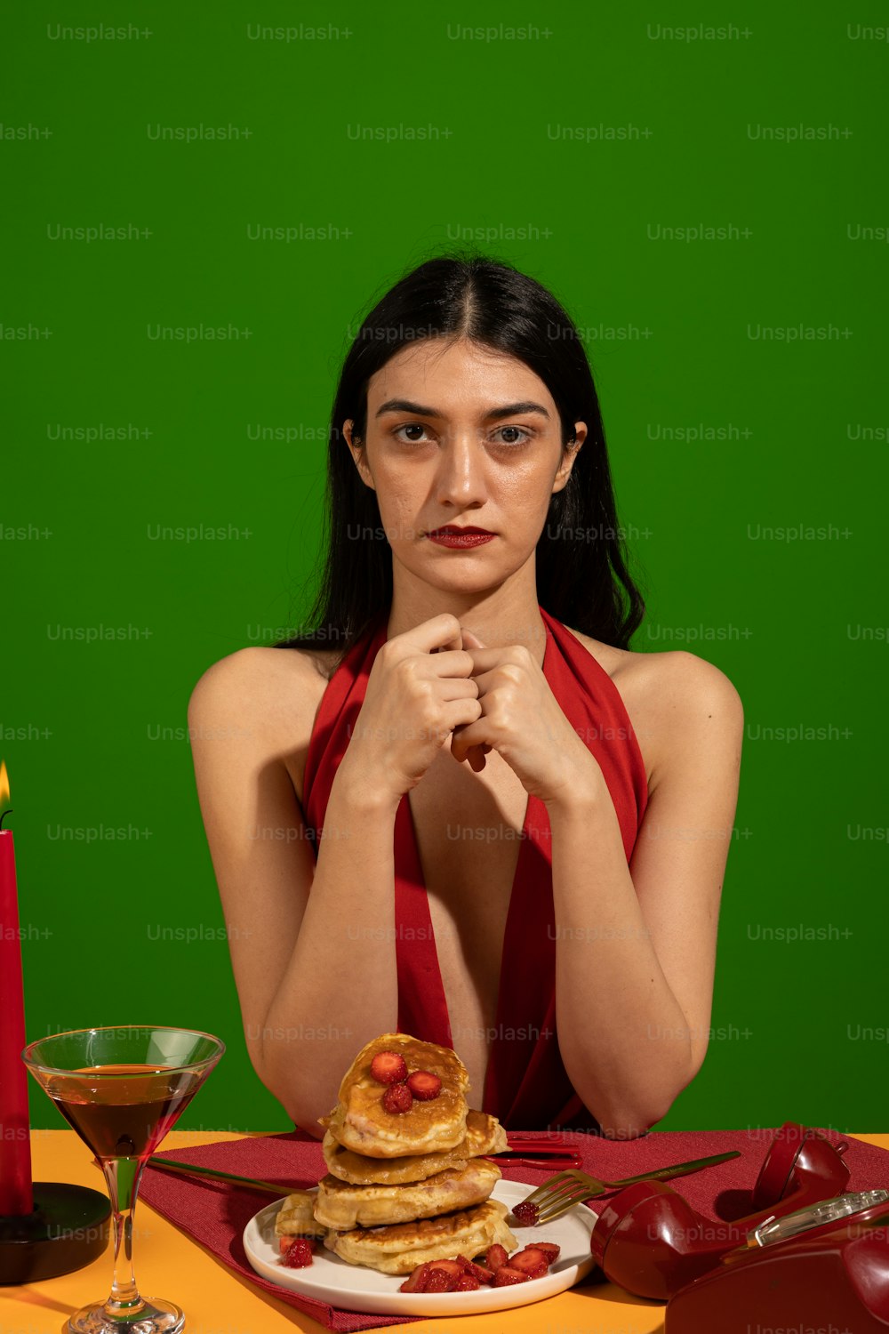 Una mujer sentada en una mesa con un plato de panqueques