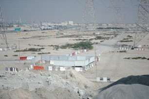 a view of a dirt field with power lines in the background