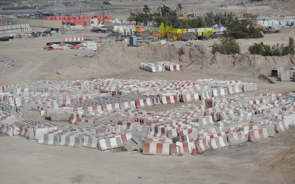 a large group of cement blocks sitting on top of a dirt field