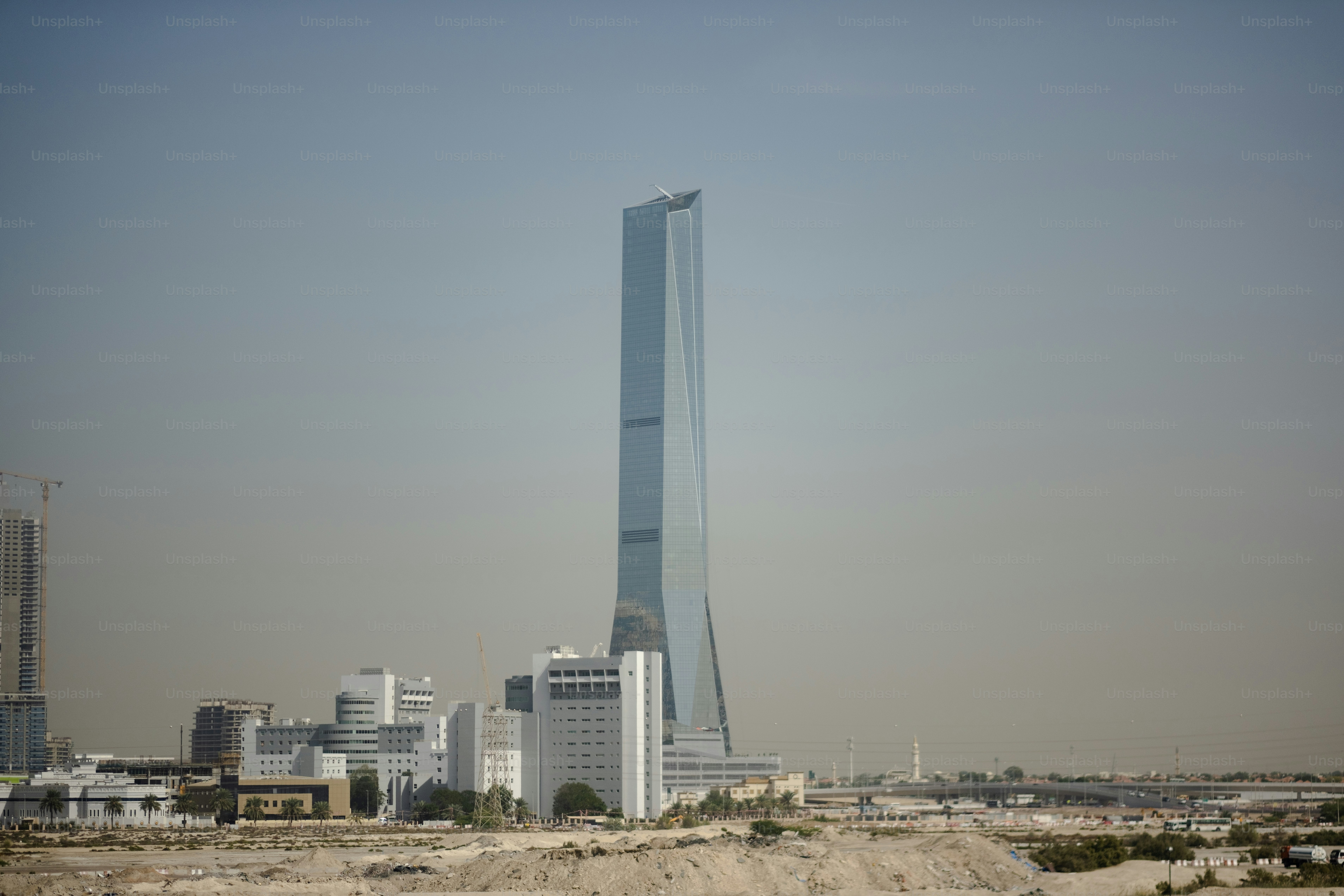 A high-rise towers over surrounding construction in the desert.