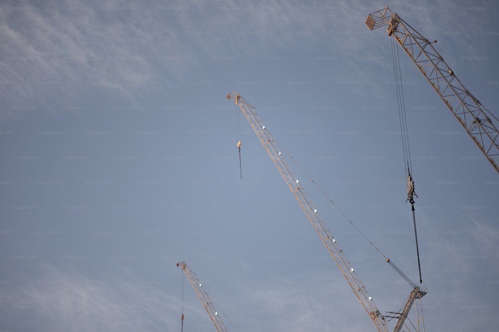 a group of cranes that are standing in the sky