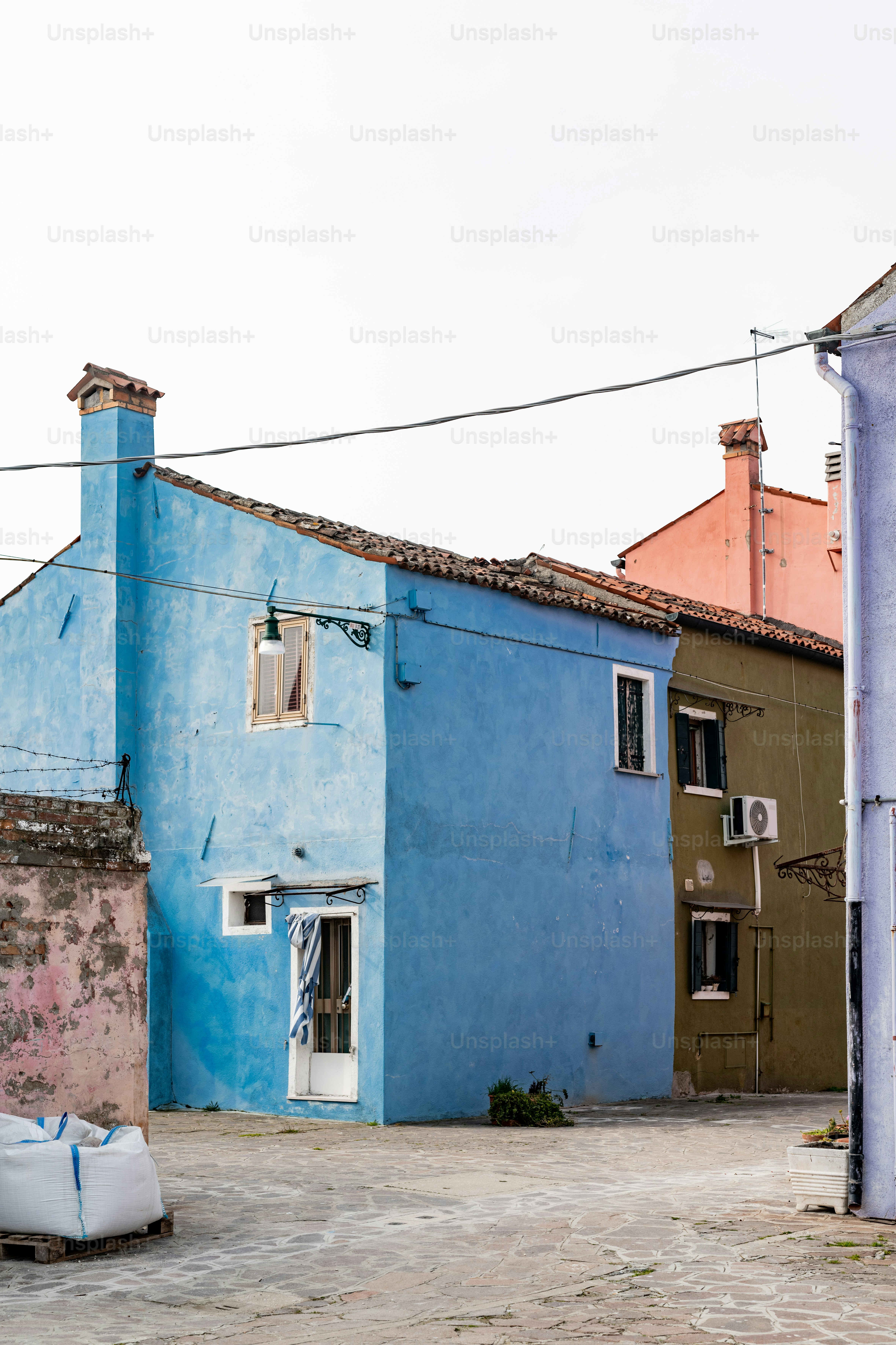 Un edificio azul con una puerta y ventanas blancas