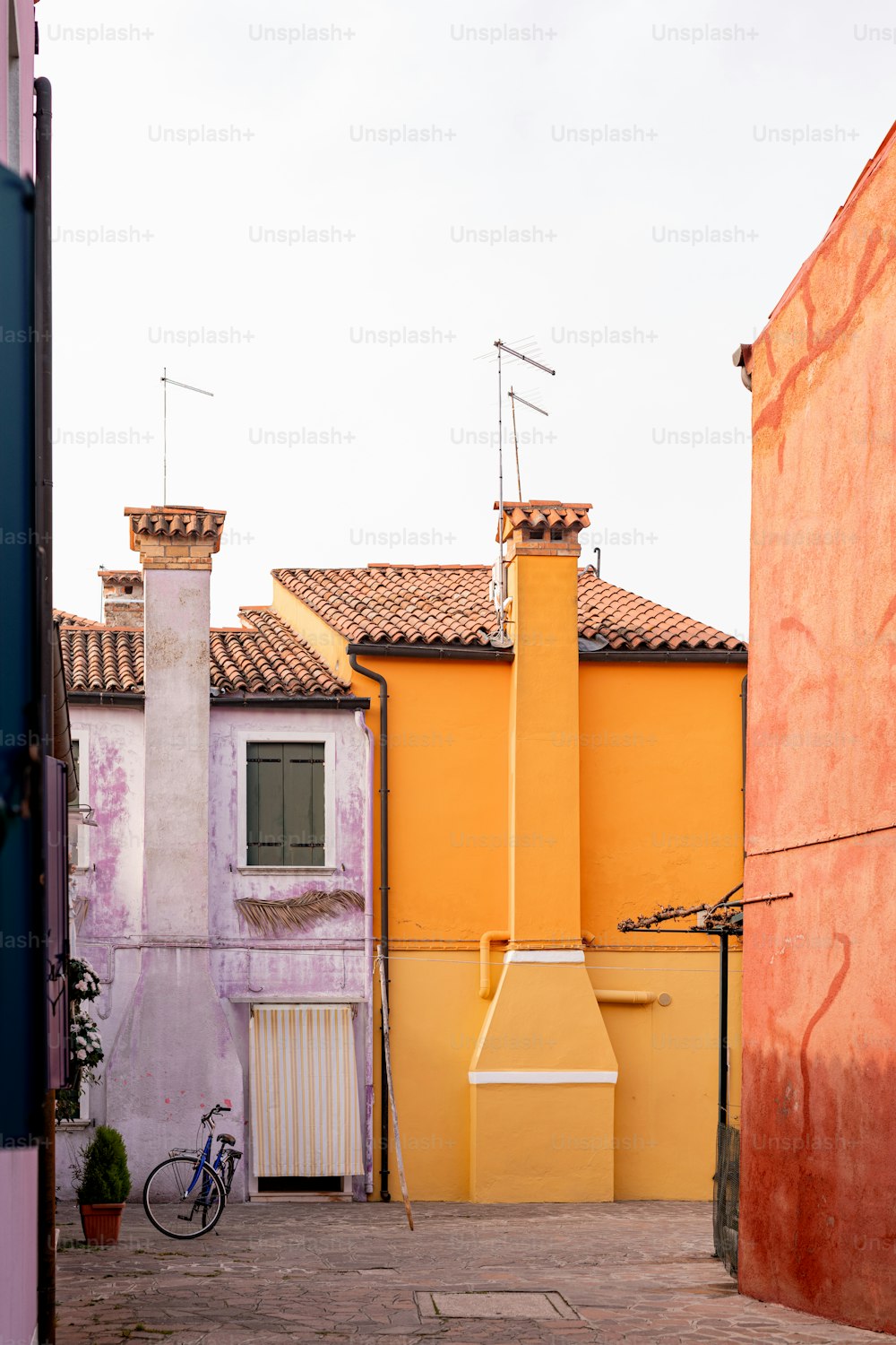 um edifício amarelo com uma bicicleta estacionada em frente a ele