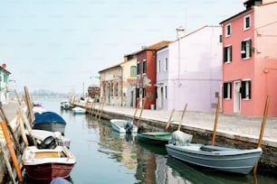 a row of boats sitting next to a pink building