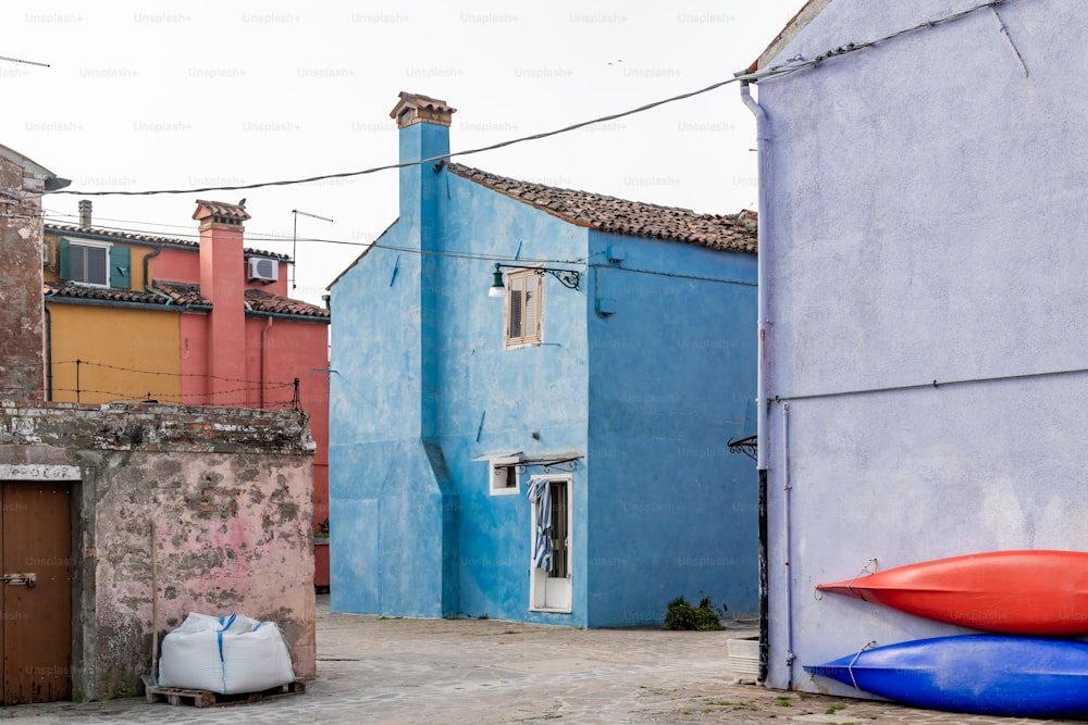 a blue building with a red boat on the ground